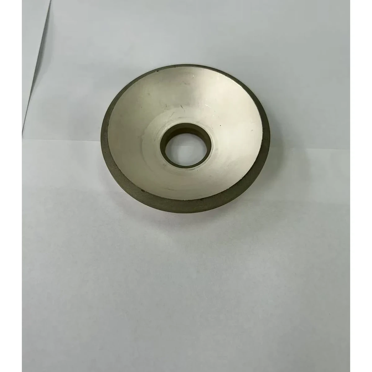 قطعة بيزو كبيرة بغطاء كروي ذي فتحة حلقية معروضة باليد لمراجعة التفاوتات والحساسية