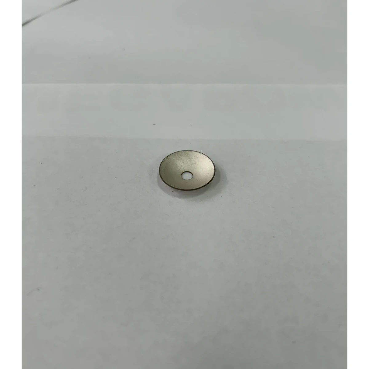 قطعة بيزو مصغرة بغطاء كروي ذي فتحة توضح قرارات التصميم المركّز المرتبطة بالفتحة