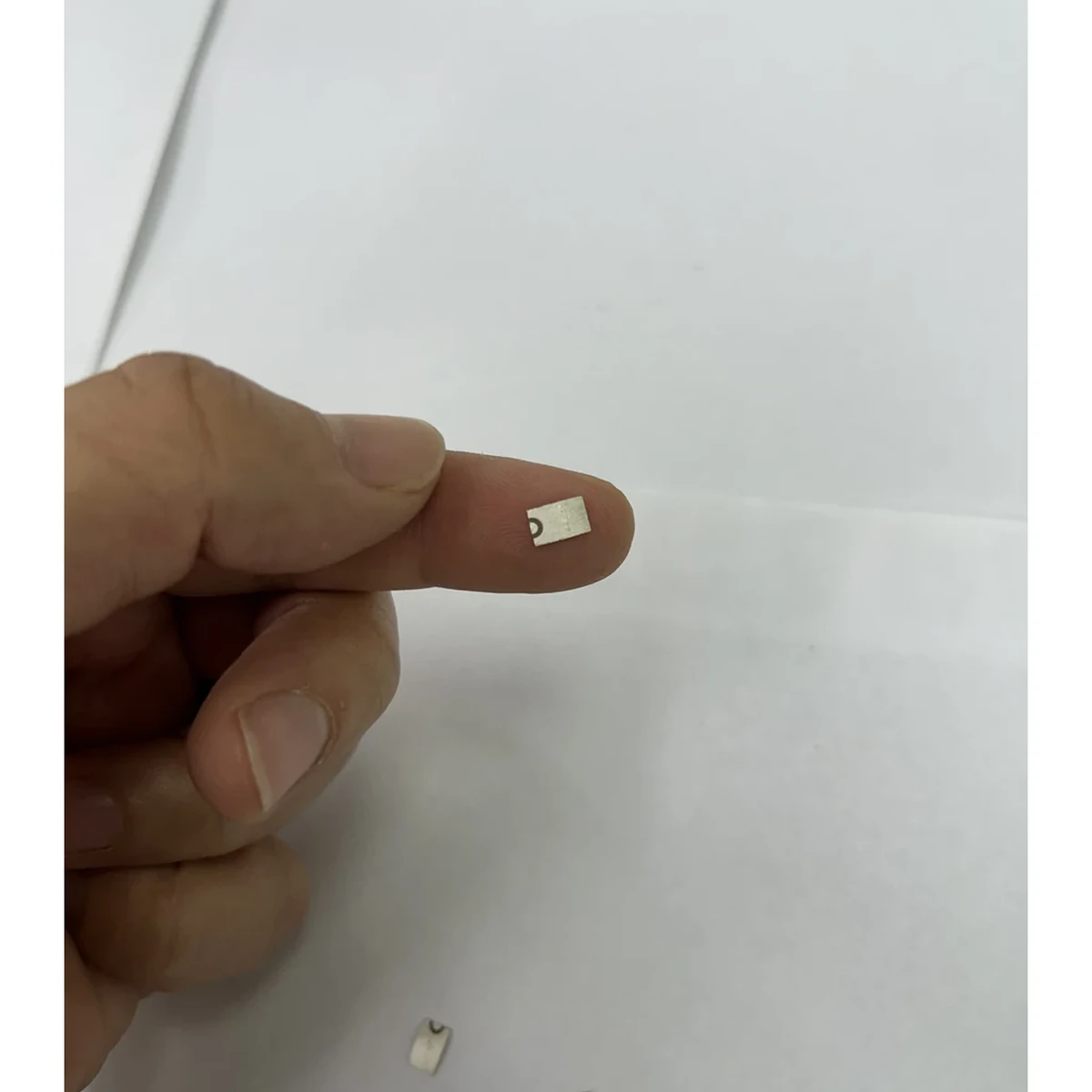 شريحة بيزو منحنية دقيقة معروضة على طرف الإصبع لمراجعة مؤشرات التحذير والفحص الأولي